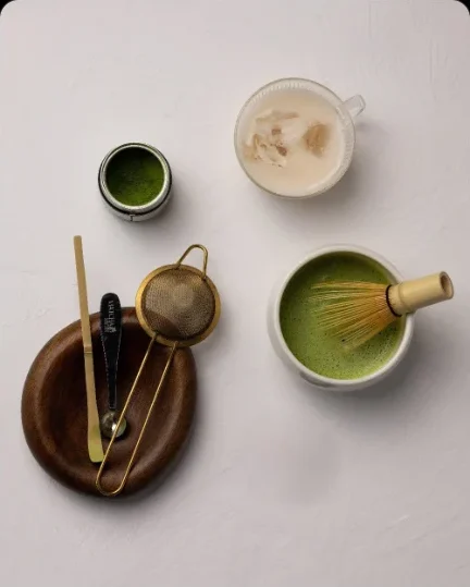 Matcha tools: whisk, spoon, sieve and a bowl of matcha